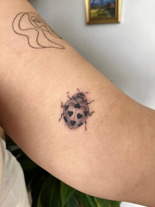 Small Fine Line Ladybug Tattoo on Women Arm by @mir0sine