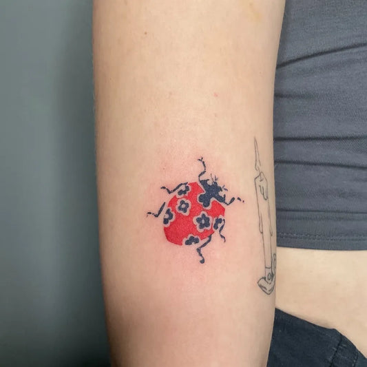 Small Fine Line Ladybug Tattoo on Women Arm by @panimeldy