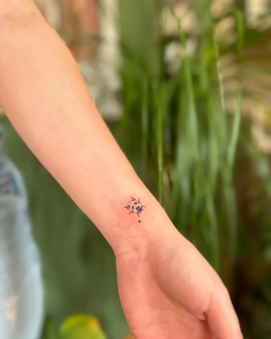 Small Fine Line Ladybug Tattoo on Women Wrist by @astridceline.tattoo