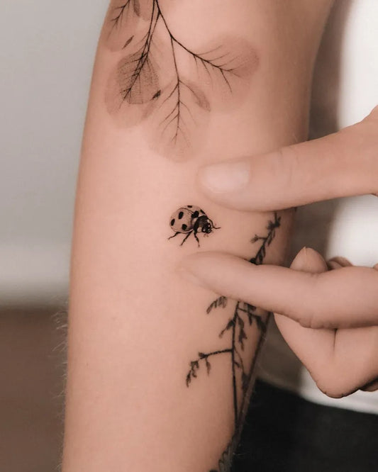 Small Fine Line Ladybug and Branches Tattoo on Women Arm by @_nico.nic_