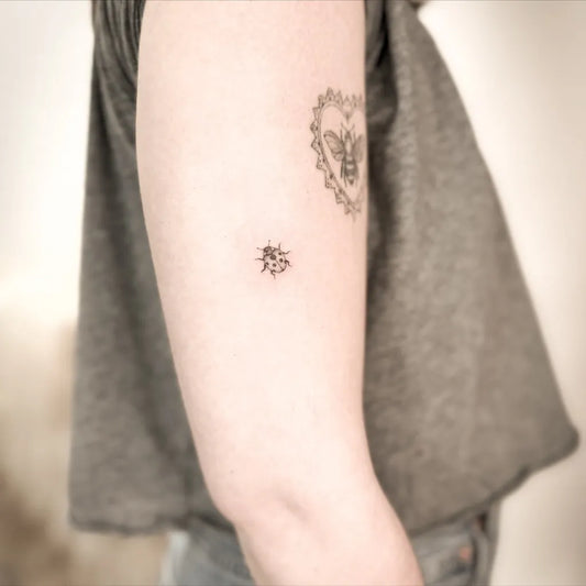 Small Fine Line Ladybug and Japanese Characters Tattoo on Women Arm by @ellie_s.tattoo