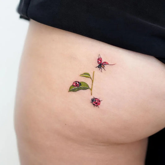Small Fine Line Ladybug and Leaf Tattoo on Women Hip by @oooooatmeal
