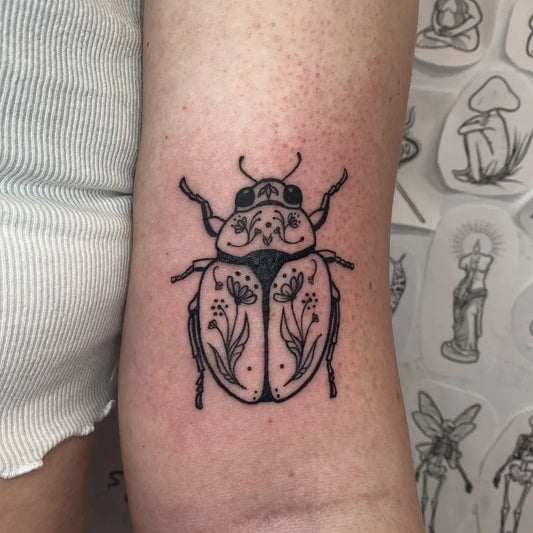 Small Fine Line Ladybug with Flowers Tattoo on Women Arm by @itssvink