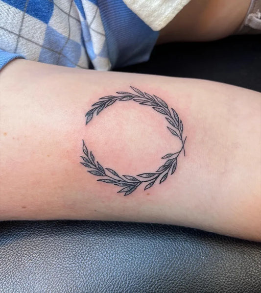 Small Fine Line Laurel Wreath Tattoo on Women Forearm by @tattoosbyhailey