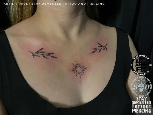 Small Fine Line Laurel Wreath and Sun Tattoo on Women Chest by @needles.and.giggles