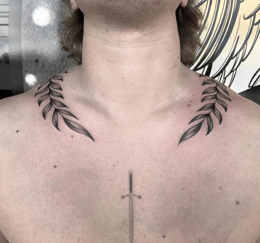 Small Fine Line Laurel Wreath and Sword Tattoo on Men Collarbone by @x.unholy.ally.x