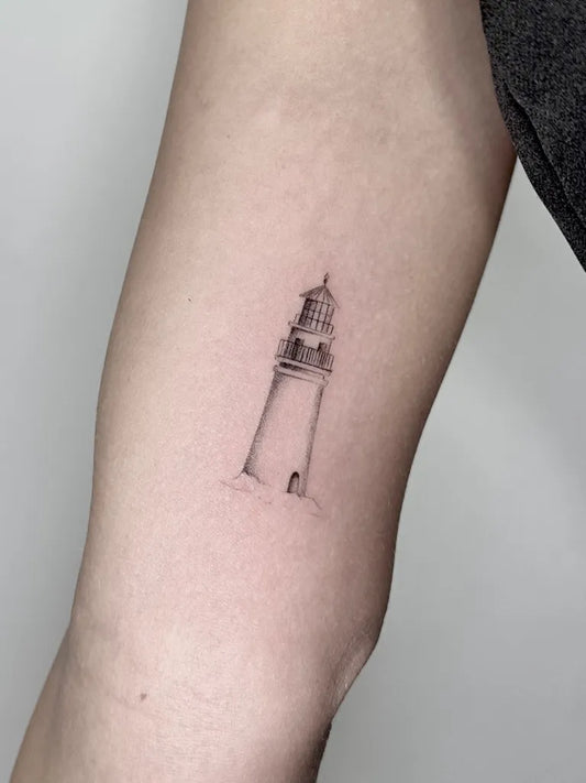 Small Fine Line Lighthouse Tattoo on Women Upper Arm by @miguelangelbellidotattoo