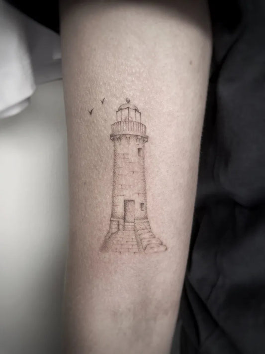 Small Fine Line Lighthouse and Birds Tattoo on Women Arm by @svartsalt.stickandpoke