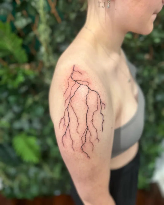 Small Fine Line Lightning Bolt Tattoo on Women Shoulder by @inkypalette.tattoos