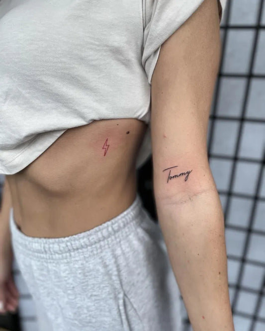 Small Fine Line Lightning Bolt and Name Tattoo on Women Arm by @drewellyntattoo