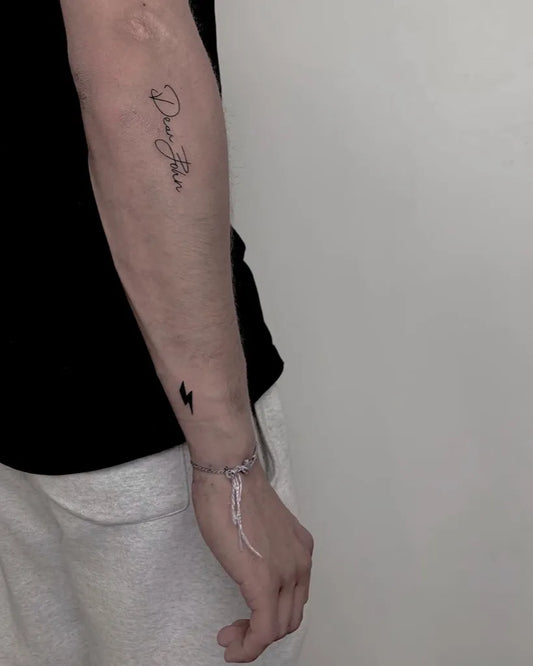 Small Fine Line Lightning Bolt and Script Tattoo on Men Arm by @didi_tattooo