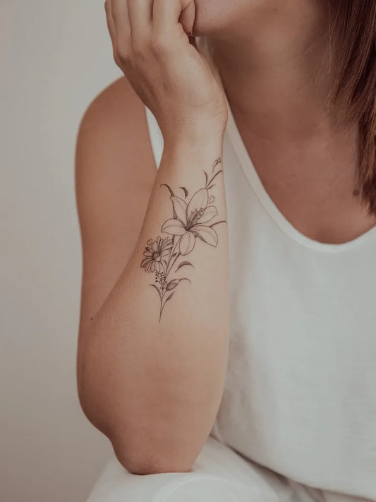 Small Fine Line Lily Flower Branch on Women Wrist Tattoo by @mona_tattoo