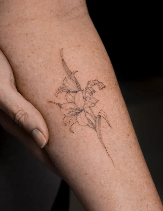 Small Fine Line Lily Flower on Women Arm Tattoo by @rafu.ink