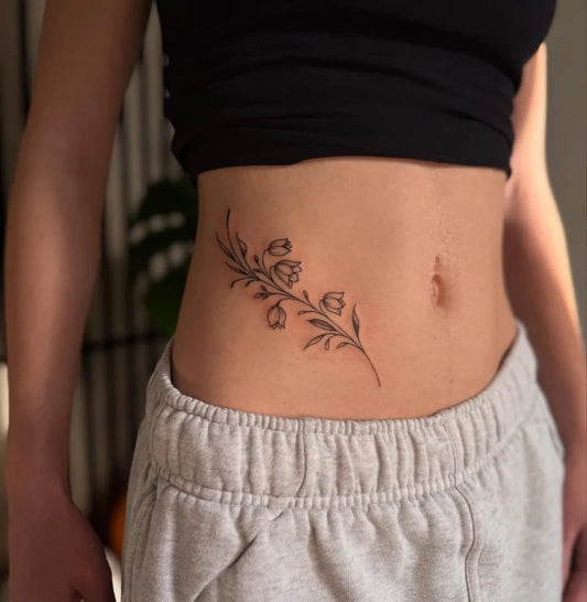 Small Fine Line Lily of the Valley Branch on Women Waist Tattoo by @toancruisetattoo