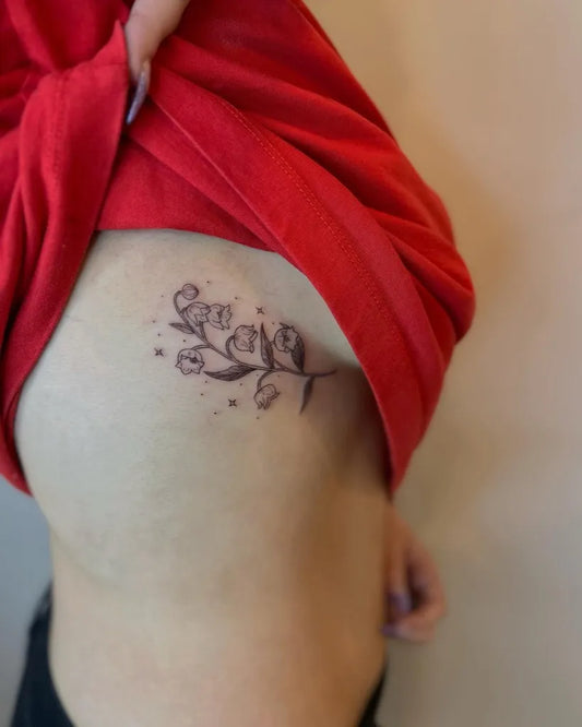 Small Fine Line Lily of the Valley and Stars on Women Ribs Tattoo by @moha.tattoo