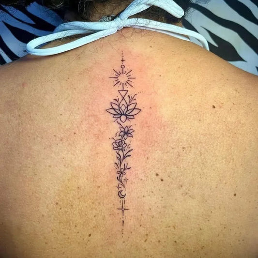 Small Fine Line Lotus Flower Spine on Women Back Tattoo by @ibu_tattoo