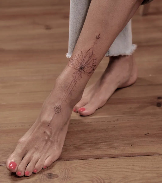 Small Fine Line Lotus Flower Tattoo on Women Ankle by @alena.ink