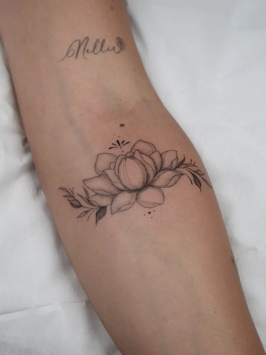 Small Fine Line Lotus Flower and Leaves on Women Forearm Tattoo by @rachelgros_tattoos