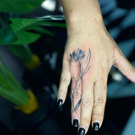 Small Fine Line Lotus Flower with Leaves on Women Hand Tattoo by @seminyakink_finelineartwork