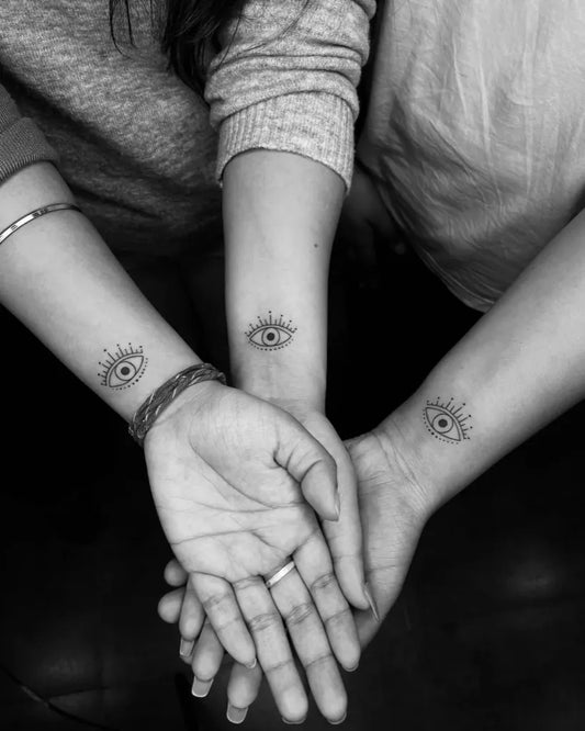 Small Fine Line Matching Evil Eye on Women Wrist Tattoo by @inkvilla_tattoostudio