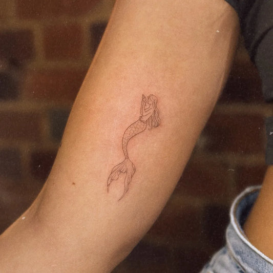 Small Fine Line Mermaid Tattoo on Women Arm by @lydiaamortattoo