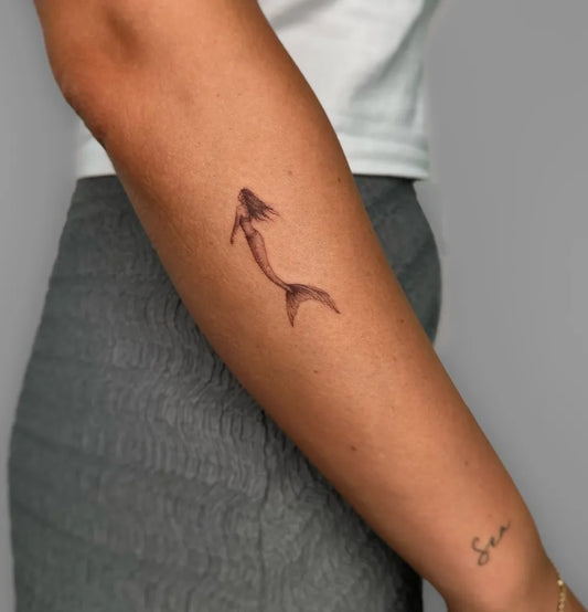 Small Fine Line Mermaid Tattoo on Women Arm by @mariam.tattoo