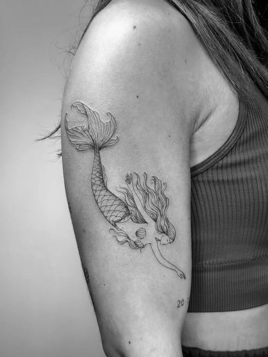 Small Fine Line Mermaid Tattoo on Women Shoulder by @letis.tattoo