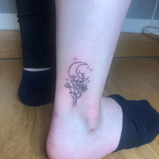 Small Fine Line Moon and Flowers Tattoo on Women Ankle by @tattoos._niki