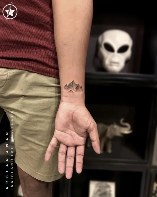 Small Fine Line Mountain Tattoo on Men Wrist by @inkisland.studio