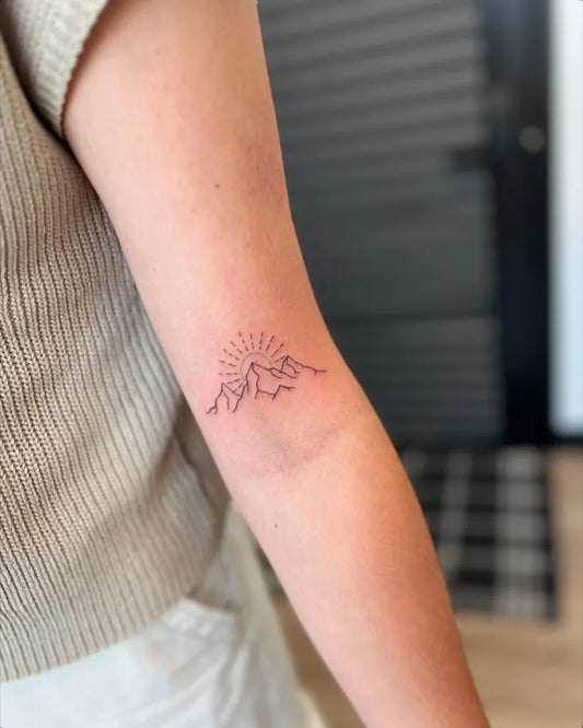 Small Fine Line Mountain and Sun Tattoo on Women Arm by @lucky_you_tattoo_
