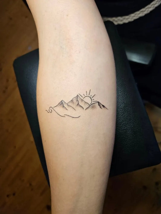 Small Fine Line Mountain and Sun Tattoo on Women Forearm by @pank_artattoo