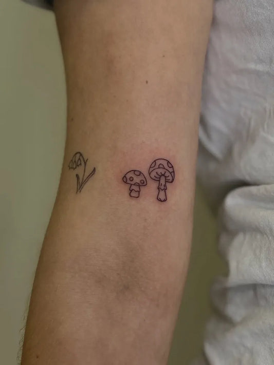Small Fine Line Mushroom and Flower on Women Arm Tattoo by @little.moments.in.ink