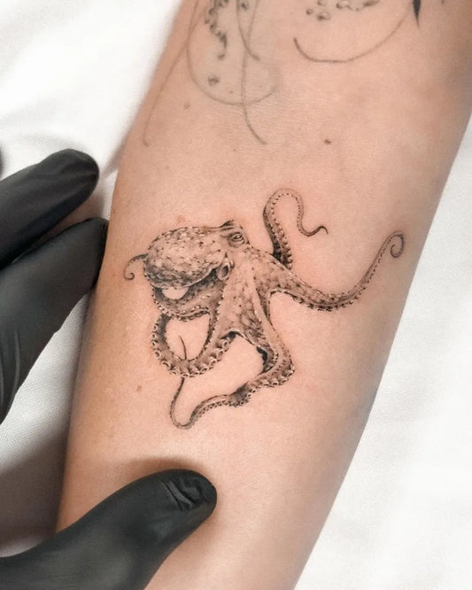 Small Fine Line Octopus Tattoo on Women Forearm by @robmcdowelltattoos