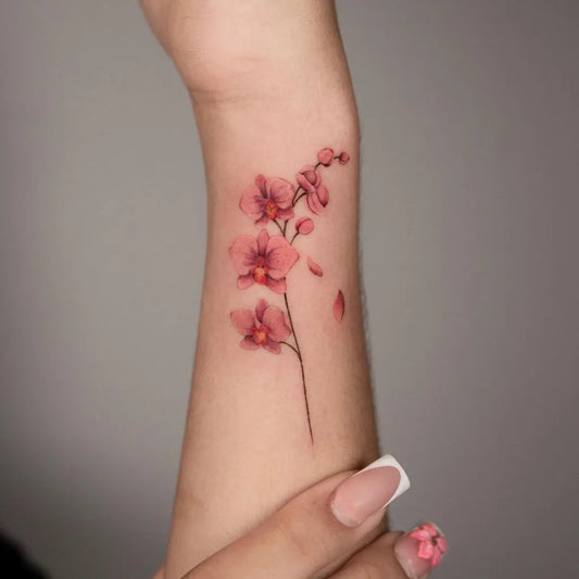 Small Fine Line Orchid Flower Tattoo on Women Wrist by @naomi.inks