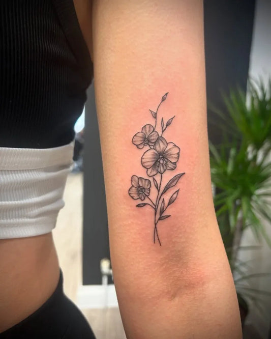 Small Fine Line Orchid Flowers Tattoo on Women Arm by @ellas_tattoos