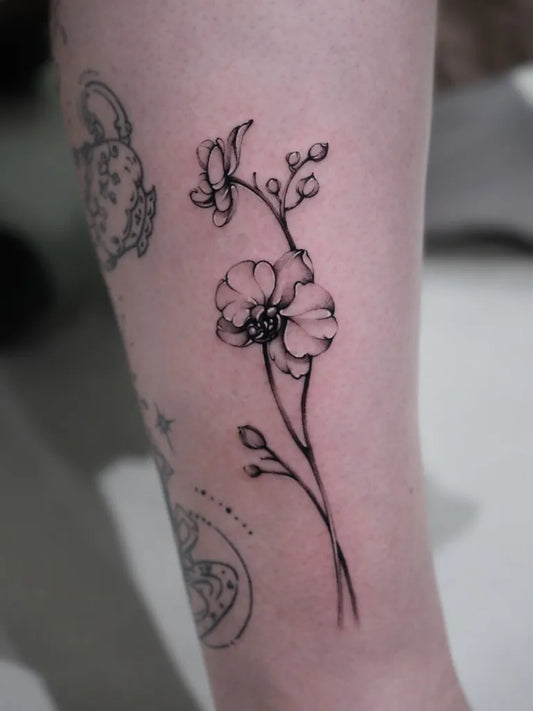 Small Fine Line Orchid Flowers Tattoo on Women Leg by @kaki_claratattoos
