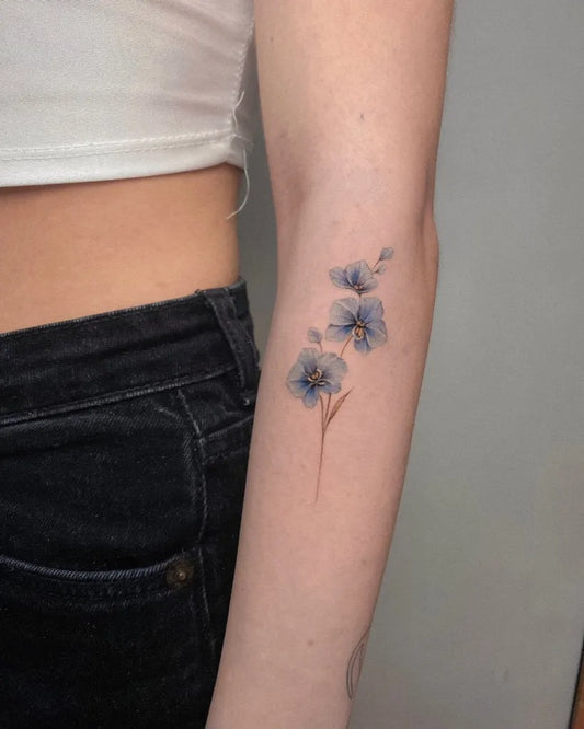 Small Fine Line Orchid Tattoo on Women Arm by @elvis_pachamamatattoo
