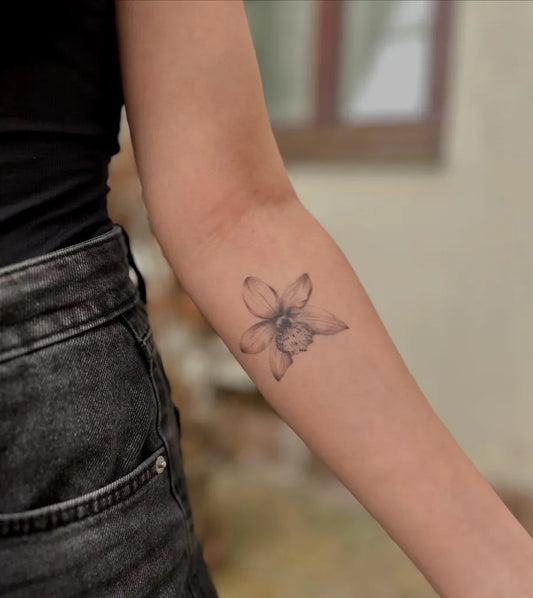 Small Fine Line Orchid Tattoo on Women Forearm by @eszter.tattoos