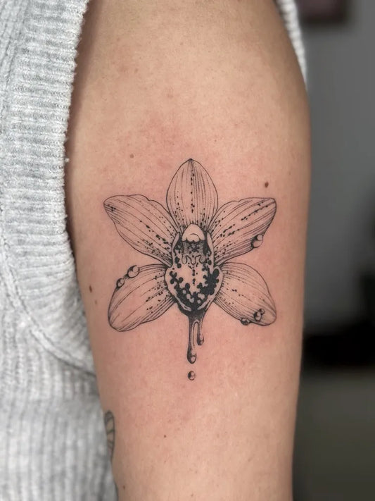 Small Fine Line Orchid Tattoo on Women Upper Arm by @celesteciafarone
