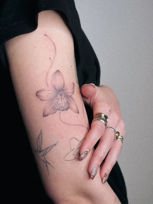 Small Fine Line Orchid and Birds Tattoo on Women Arm by @nonablooms_ink