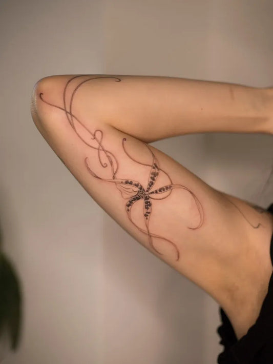 Small Fine Line Orchid and Vines Tattoo on Women Arm by @suyscene