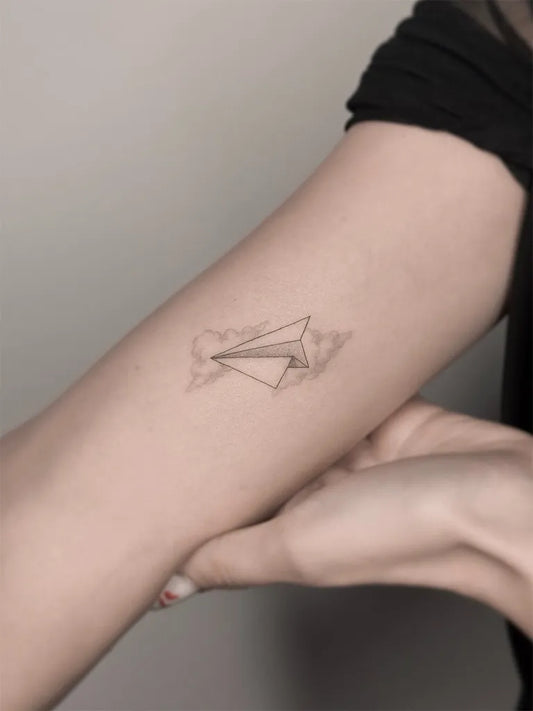 Small Fine Line Paper Airplane and Cloud Tattoo on Women Arm by @eden_tattoos