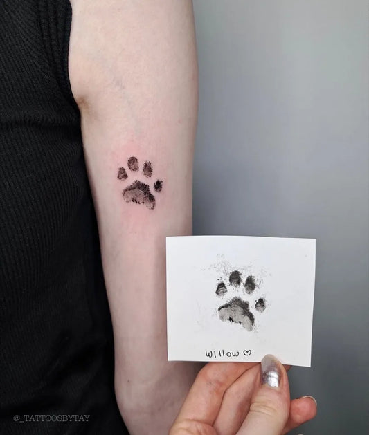 Small Fine Line Paw Print Tattoo on Women Arm by @_tattoosb