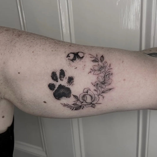 Small Fine Line Paw Print and Floral Wreath Tattoo on Women Arm by @chloetattoo