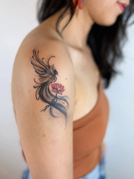 Small Fine Line Phoenix and Lotus on Women Shoulder Tattoo by @hyperink.ca