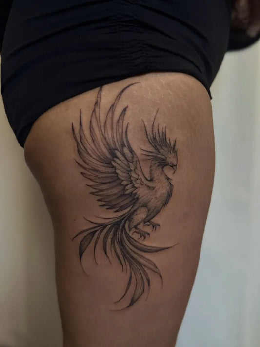 Small Fine Line Phoenix on Women Thigh Tattoo by @inkedbyjules_