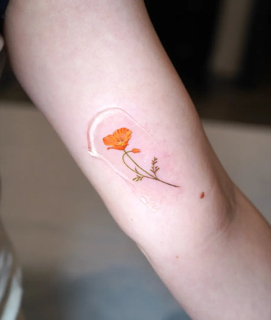 Small Fine Line Poppy Flower Tattoo on Women Arm by @tattooartbyhailey
