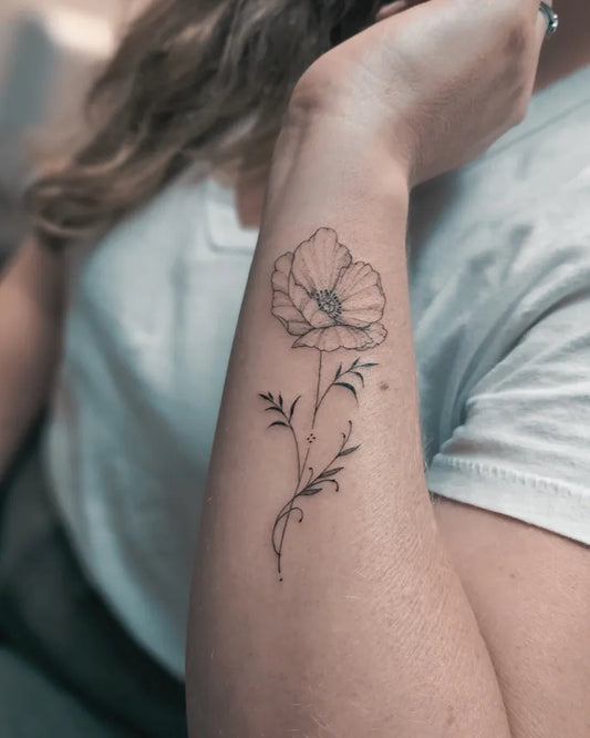 Small Fine Line Poppy Flower Tattoo on Women Wrist by @monkeys_factory_tattoo