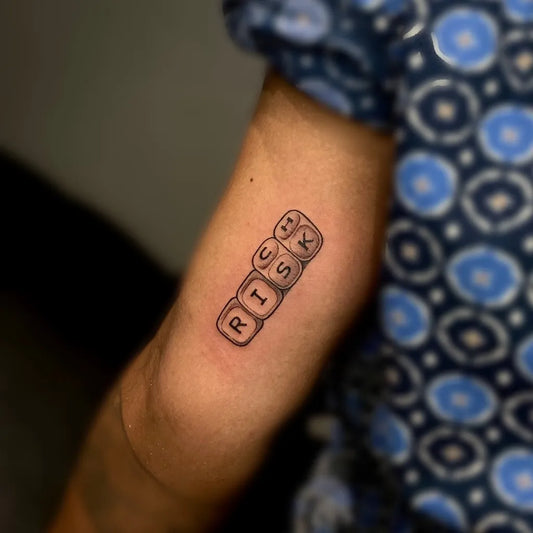 Small Fine Line RISK Dice Tattoo on Women Arm by @mupaditattoosindia
