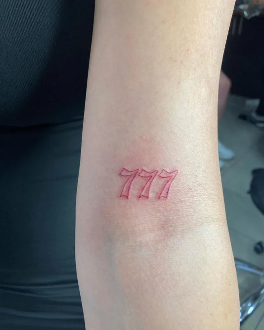 Small Fine Line Red 777 Outline Tattoo on Women Arm by @tattoo.aari